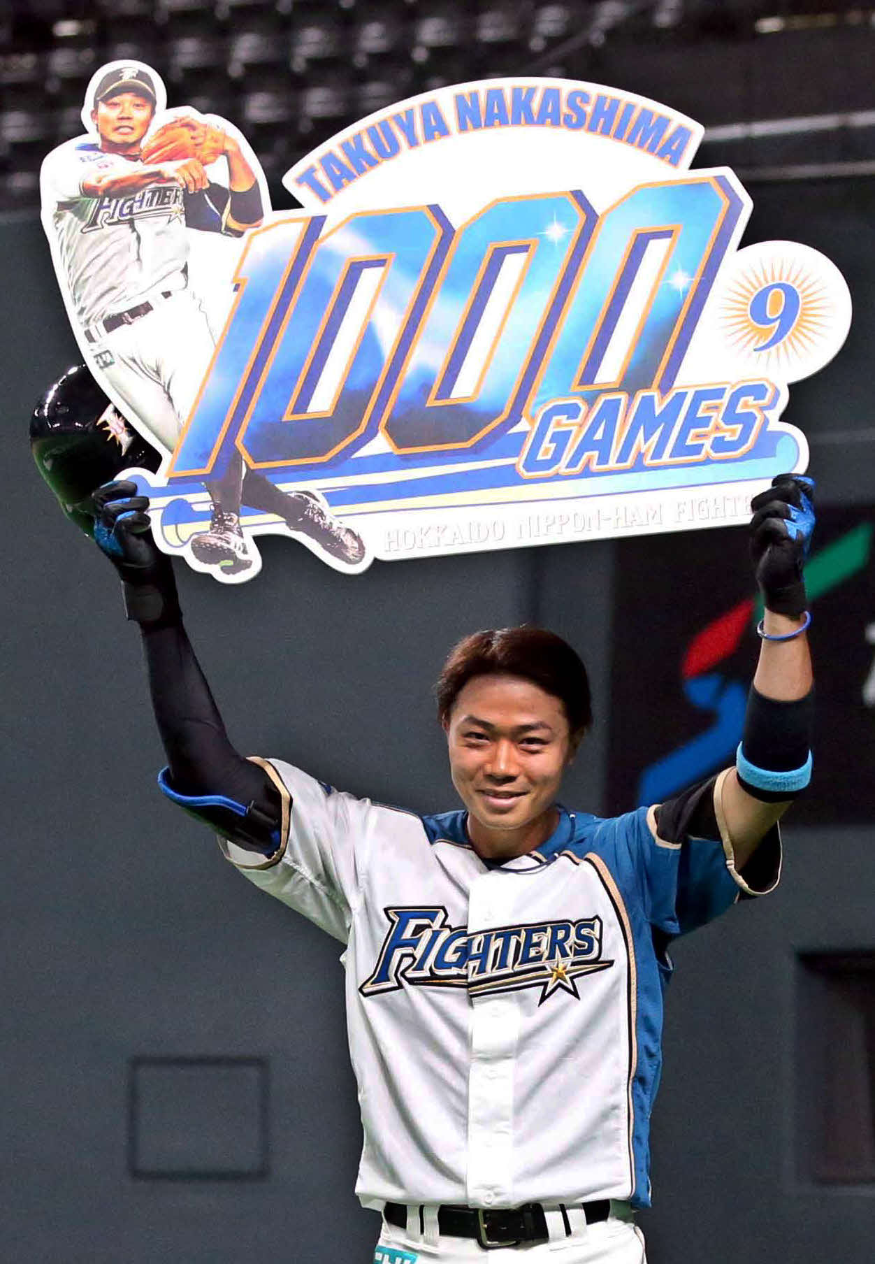 日本ハム対ソフトバンク　通算1000試合出場を達成し、記念ボードを掲げる日本ハム中島（撮影・黒川智章）