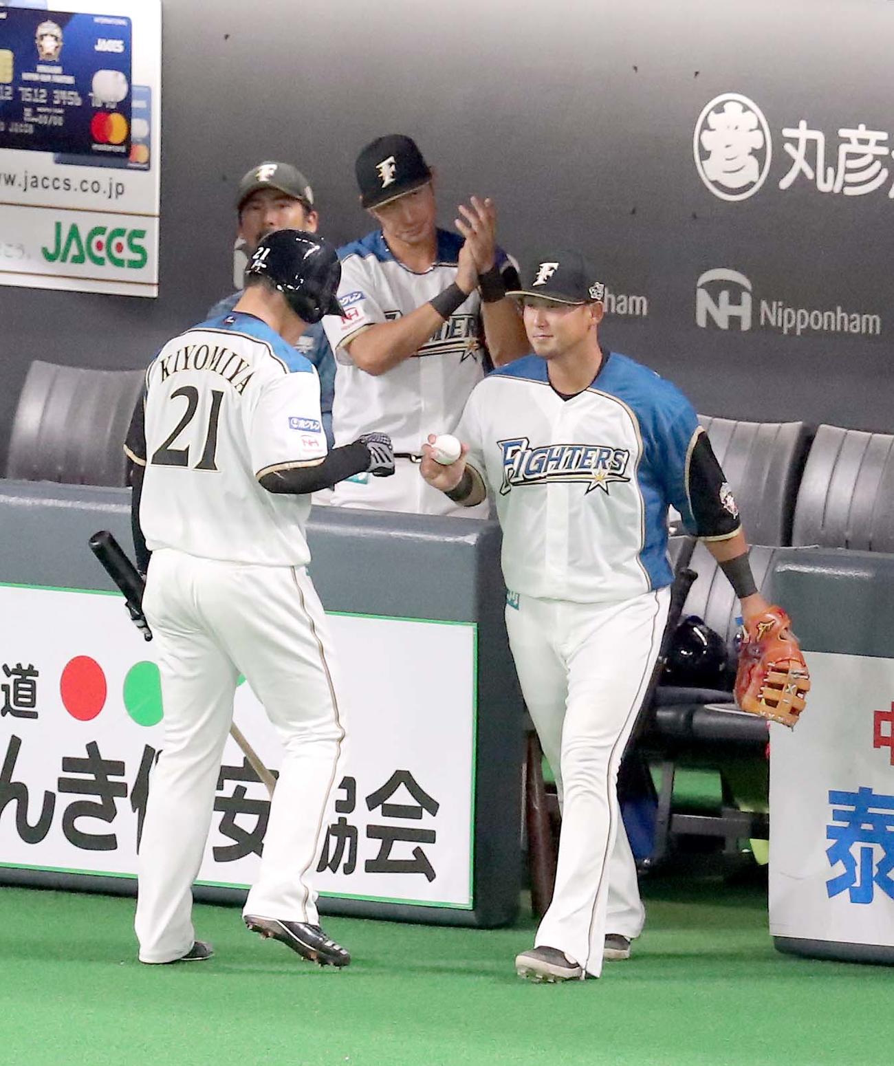 日本ハム対ソフトバンク　今季初安打を放ち、日本ハム中田（右手前）に出迎えられる清宮（撮影・佐藤翔太）