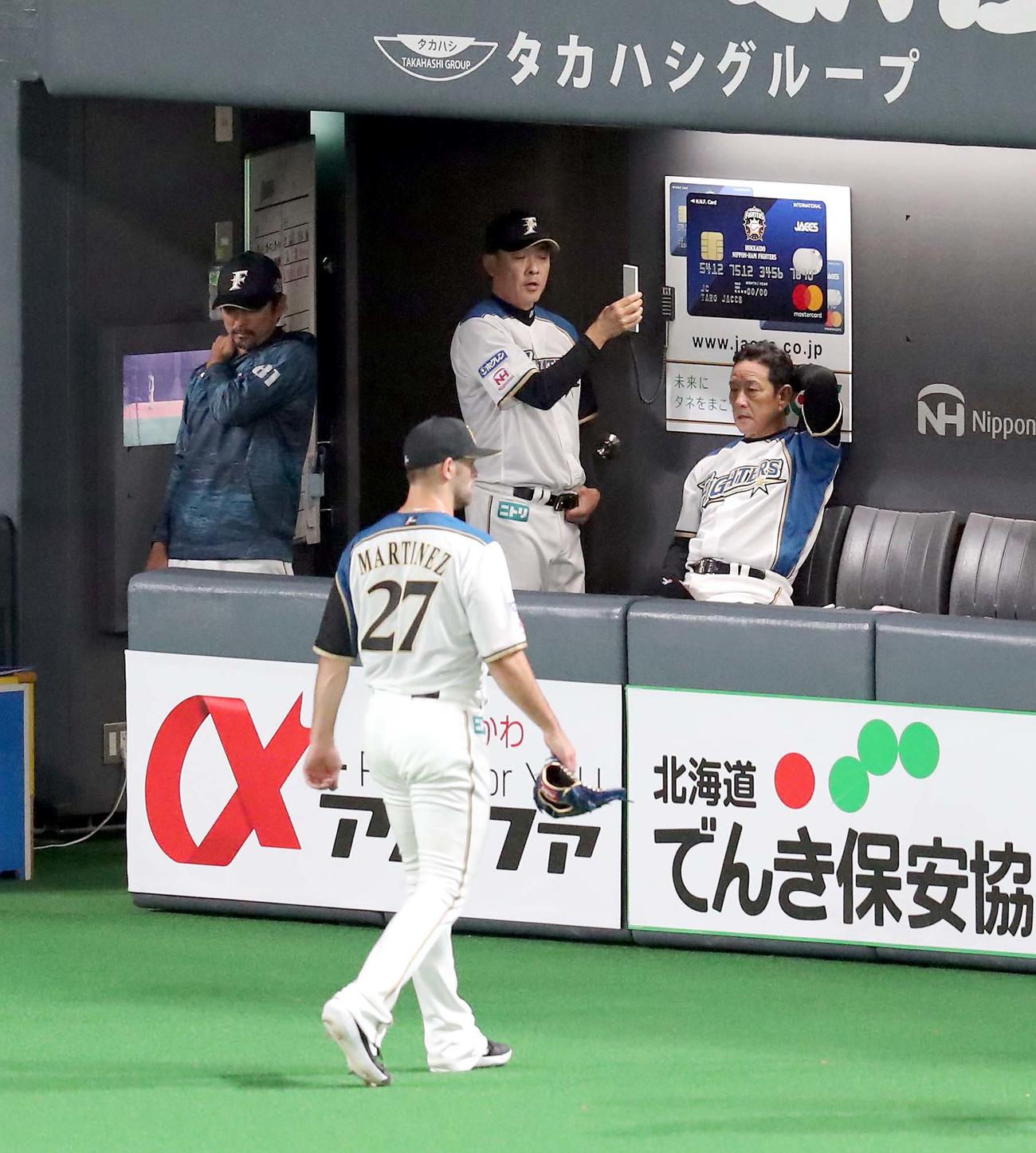 日本ハム対ソフトバンク　追加点を許し頭を抱える日本ハム栗山監督（右奥）。左手前は先発のマルティネス（撮影・佐藤翔太）