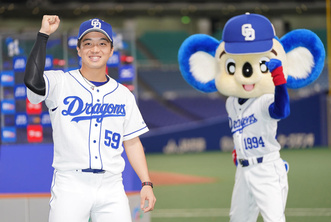 中日対阪神　ソーシャルディスタンスの距離を保ちながらポーズを決める中日山本拓実（左）とドアラ（撮影・森本幸一）