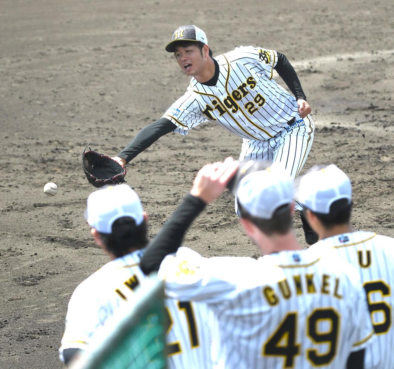 投内連係でグラブトスする阪神高橋（代表撮影）