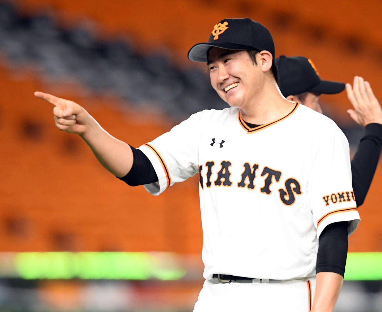 今季初完封勝利を飾った巨人菅野は、ナインの出迎えに笑顔で指をさす（撮影・たえ見朱実）