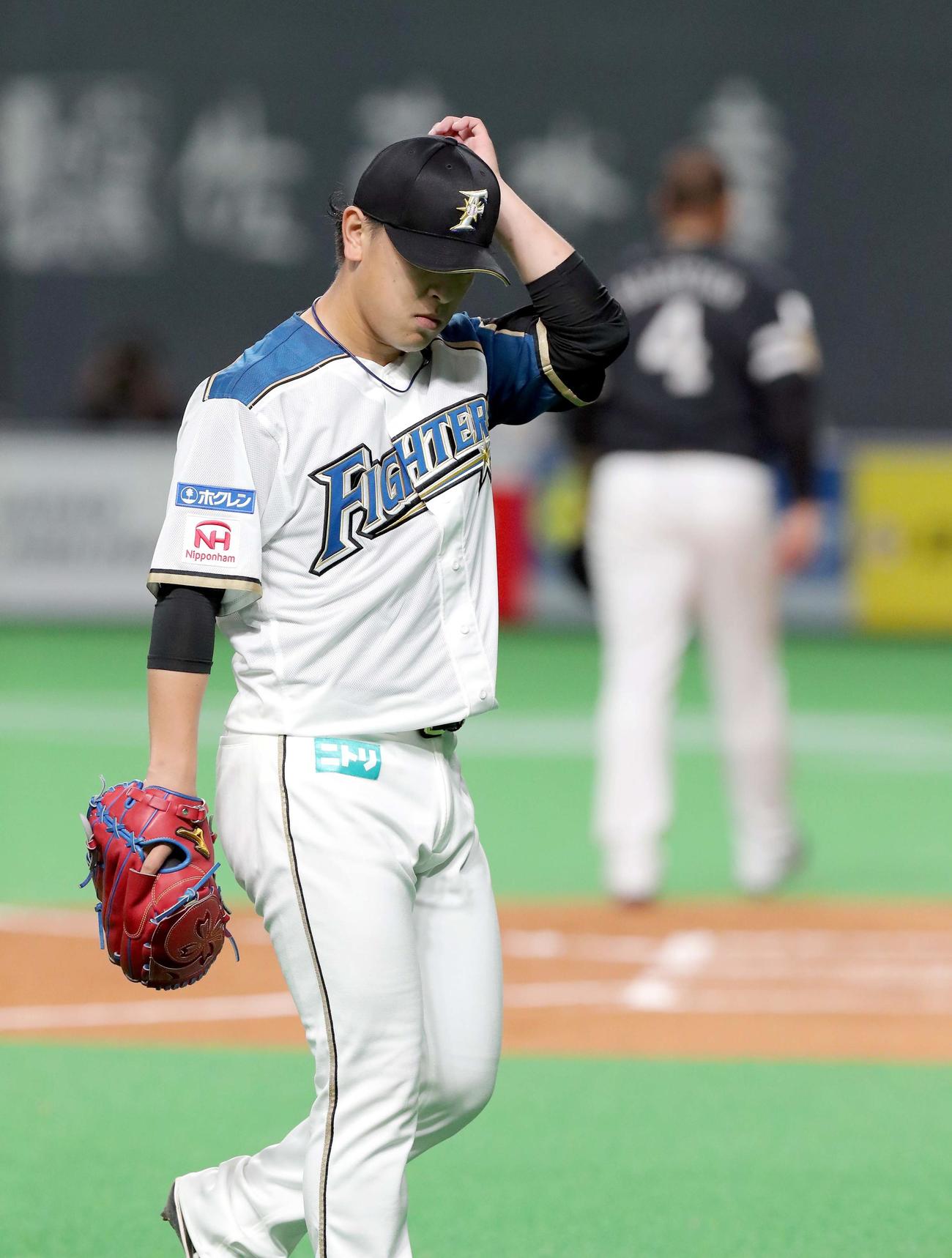 日本ハム対ソフトバンク　ソフトバンク・バレンティン（右奥）に同点となる適時二塁打を打たれうつむきながらベンチに戻る日本ハム河野（撮影・佐藤翔太）