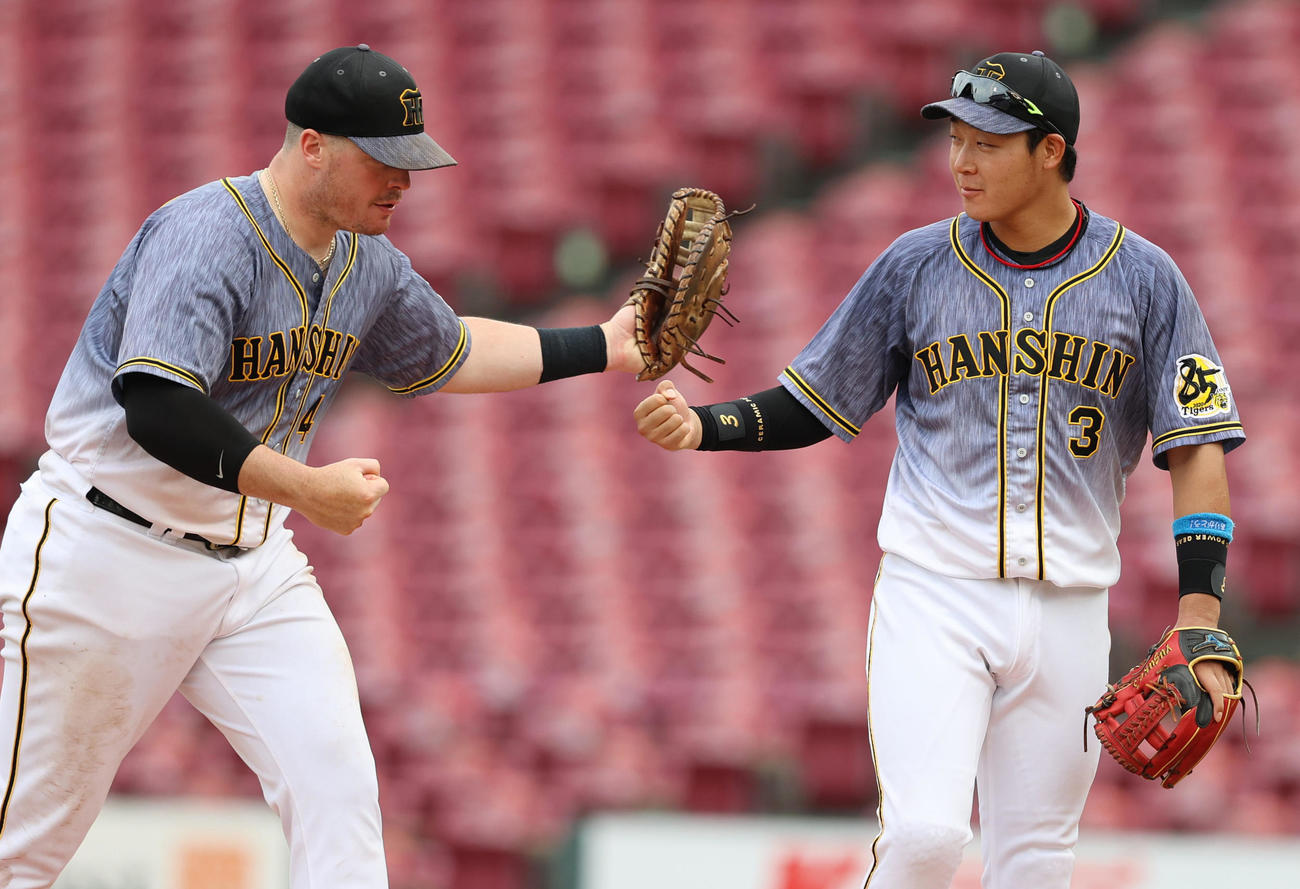 広島に連勝しタッチを交わすボーア（左）と大山悠輔（撮影・清水貴仁）