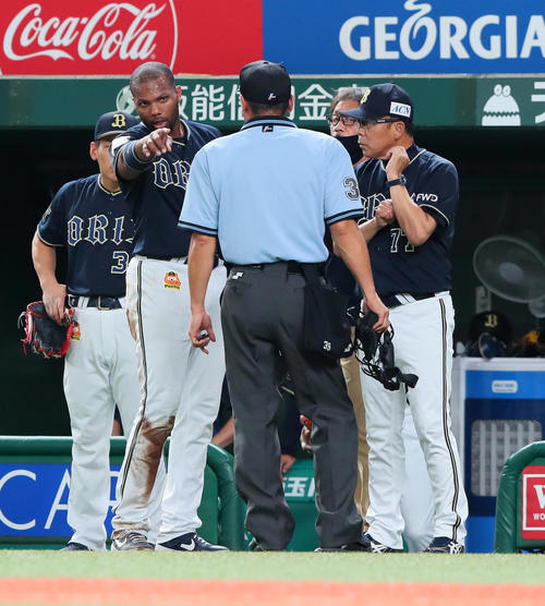 西武対オリックス　2回表オリックス2死二塁、本塁でアウトとなり警告を受けた二塁走者ロドリゲス（左）は審判団に抗議する。右は西村監督（撮影・足立雅史）