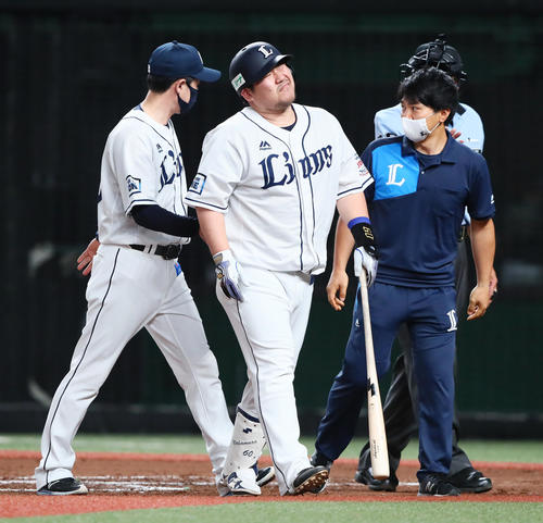 西武対オリックス　6回裏西武1死一塁、右手に死球を受けた中村（中央）は苦悶（くもん）の表情を見せる（撮影・足立雅史）