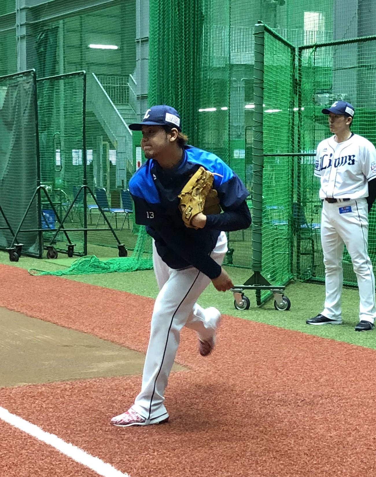 豊田投手コーチ（奥）が見守る前で練習をする西武高橋光投手（球団提供）