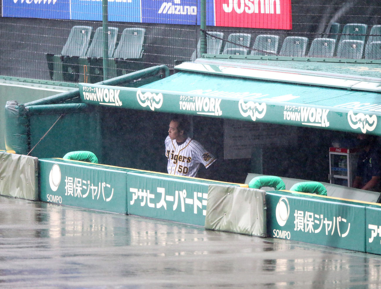 突然の雨で水浸しとなったグラウンドをベンチから眺める青柳（撮影・上山淳一）
