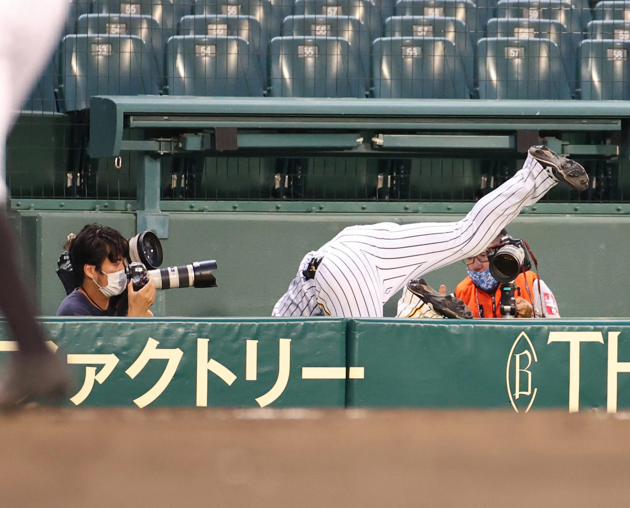 阪神対巨人　5回表巨人2死、丸佳浩の邪飛を捕った三塁手大山悠輔は勢いあまってカメラマン席に飛び込む（撮影・清水貴仁）