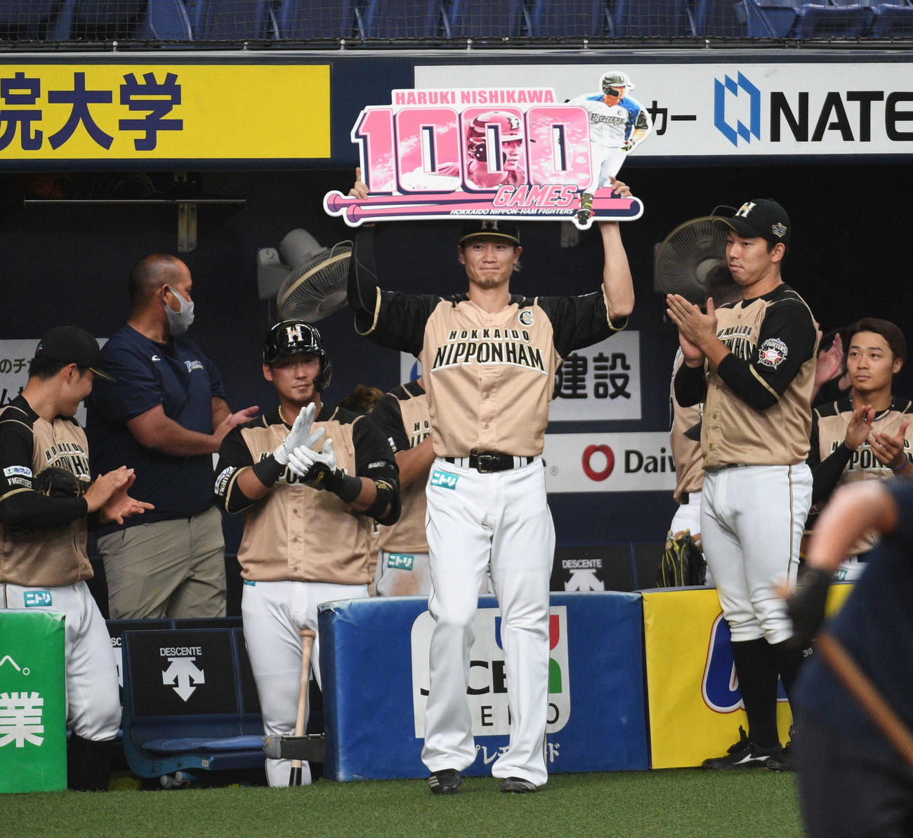 オリックス対日本ハム　1000試合出場を達成し、ボードを掲げる日本ハム西川（撮影・渦原淳）