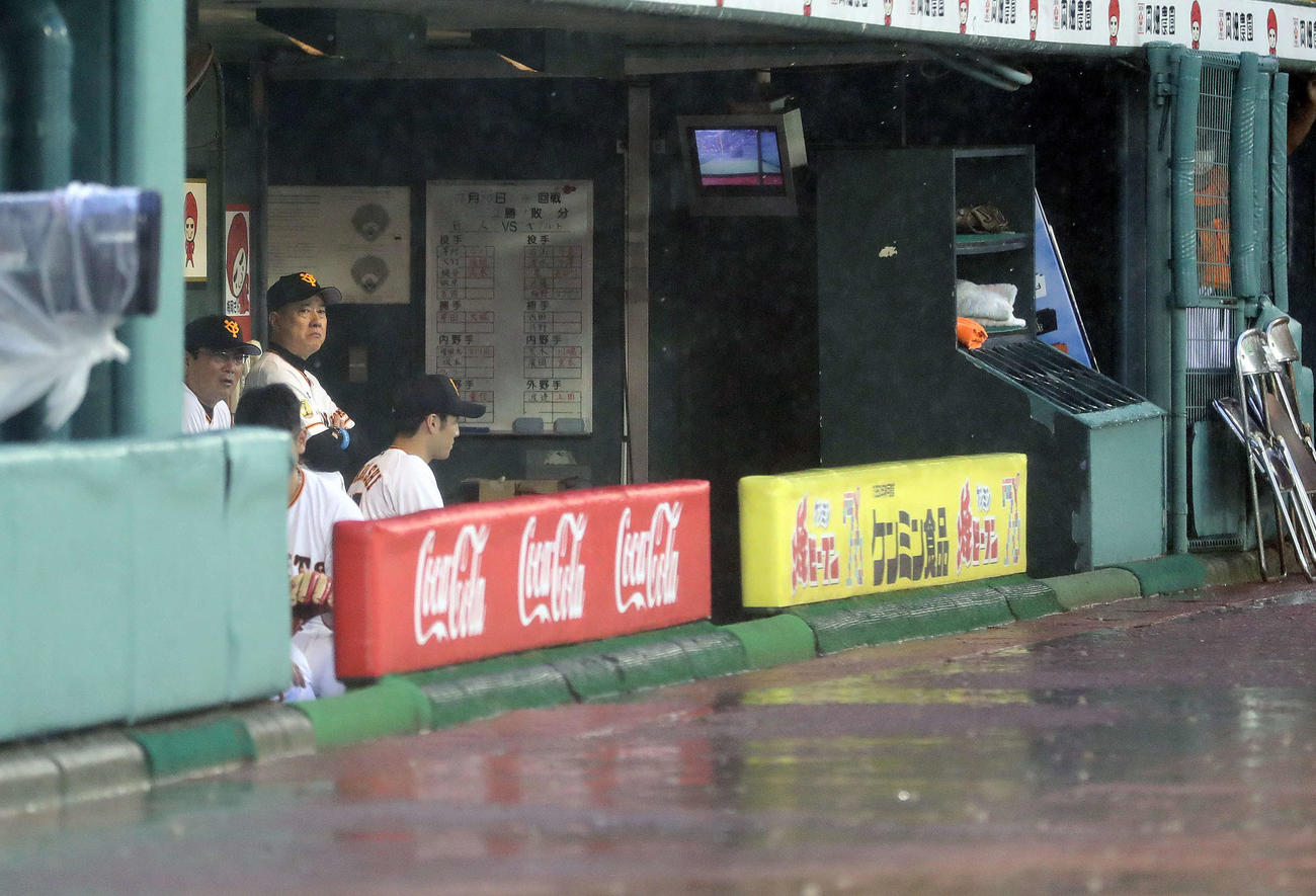 巨人対ヤクルト　試合開始前に大雨となり、険しい表情でグラウンドを見つめる巨人原監督（左後方）（撮影・河野匠）