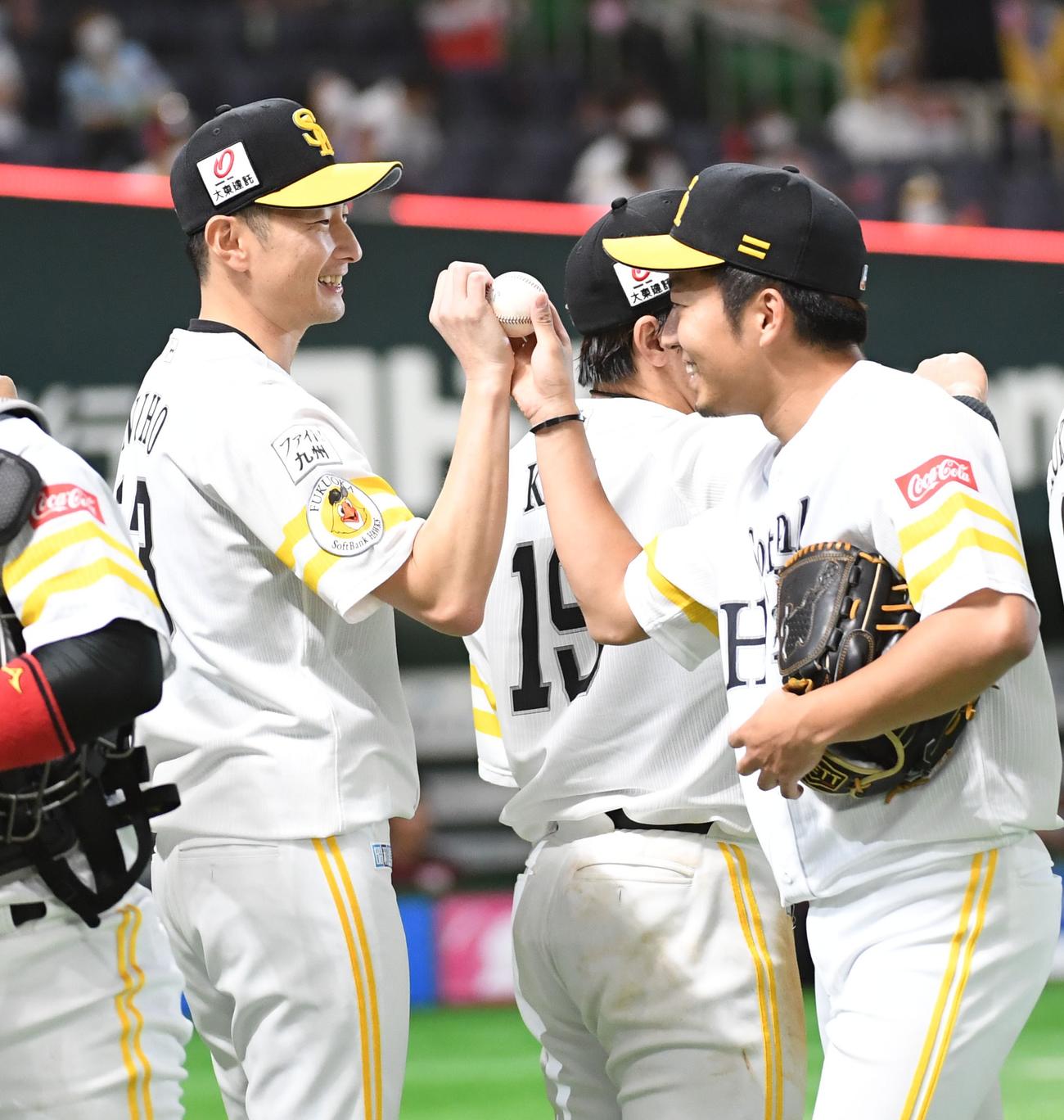 今季初勝利を挙げた二保（左）は嘉弥真からウイニングボールをを受け取る（撮影・今浪浩三）