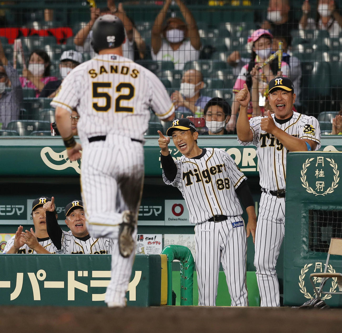 阪神対ヤクルト　4回裏阪神1死二、三塁、木浪の右犠飛で生還したサンズを笑顔で迎える矢野監督（右から2人目）ら（撮影・前田充）
