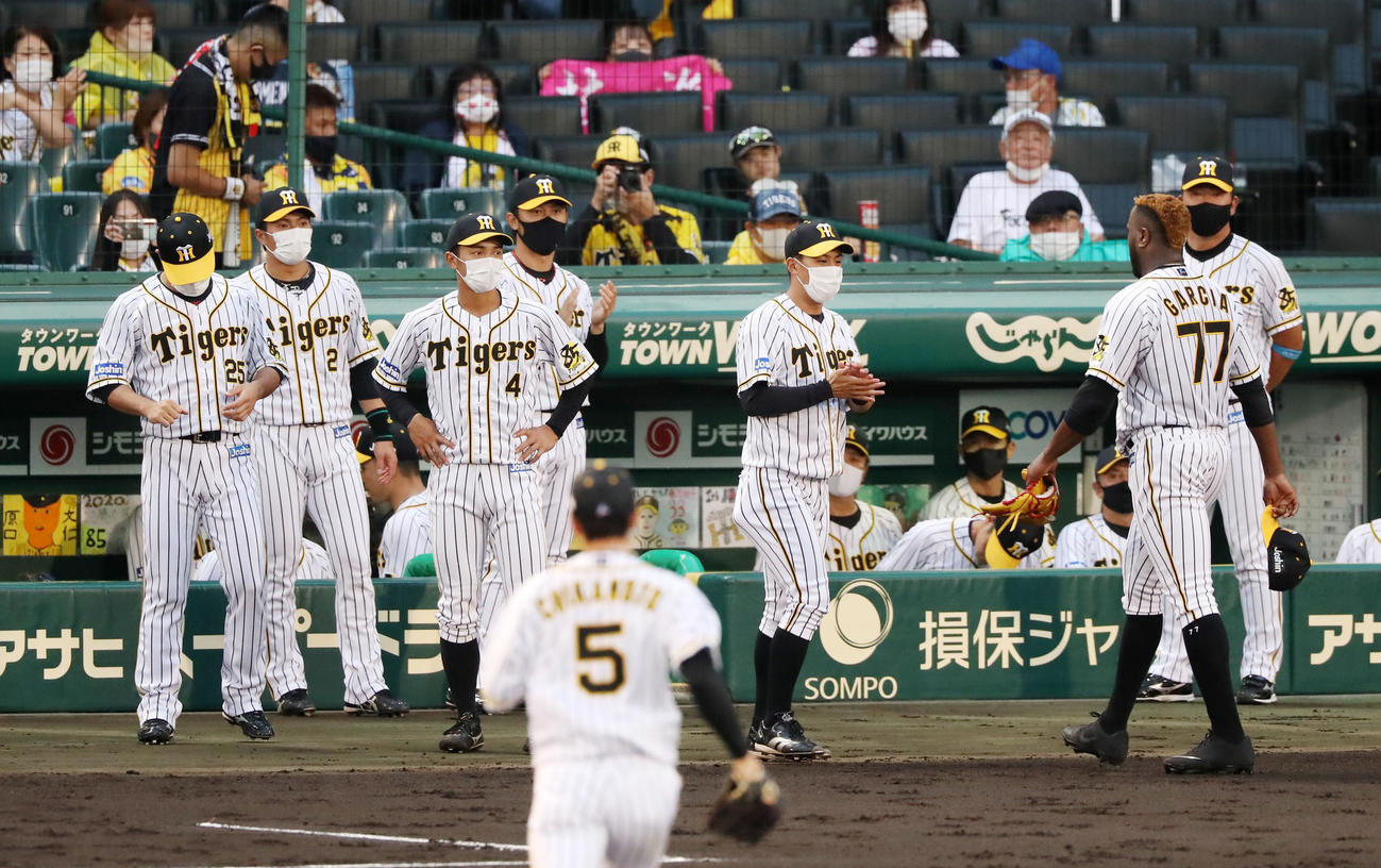 阪神対ヤクルト　3回表を終えベンチの戻るガルシア（右）を出迎えるマスク姿の阪神ナインたち（撮影・加藤哉）