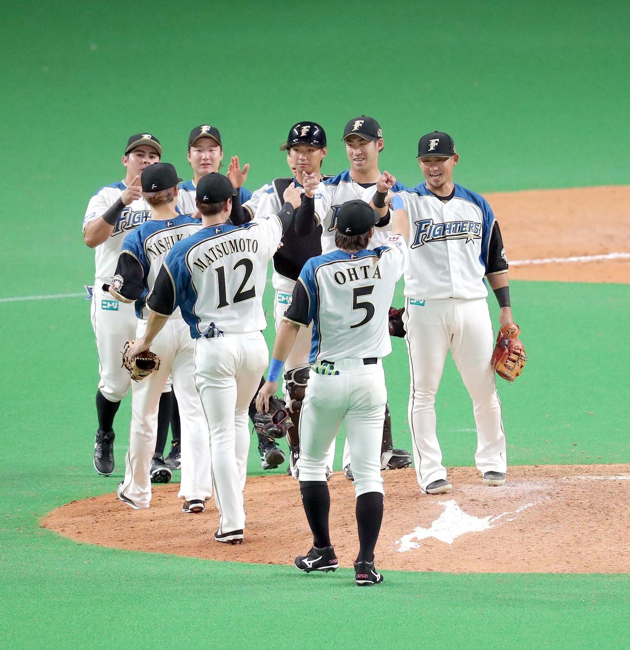 日本ハム対ロッテ　試合終了後、ナインを笑顔で出迎える日本ハム中田（右）（撮影・佐藤翔太）