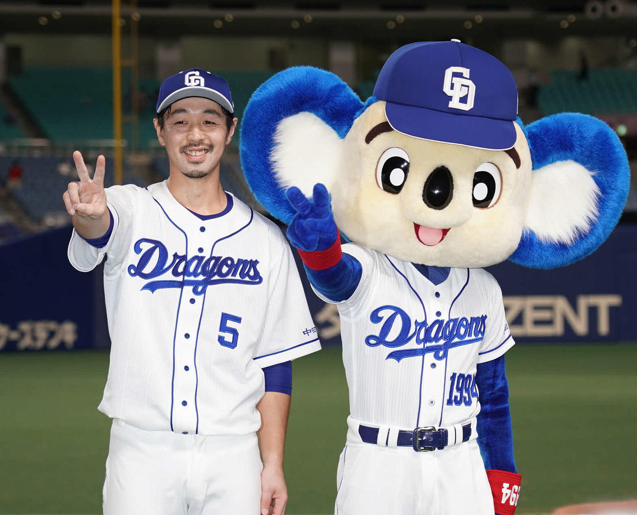 ドアラとポーズを決める阿部（撮影・森本幸一）