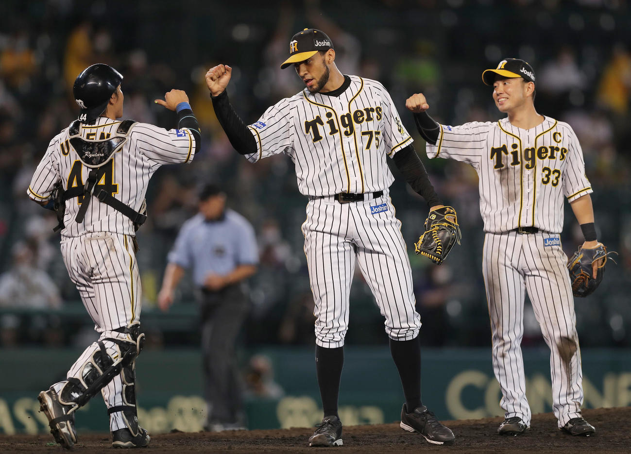 最後を締めたスアレス（中央）は梅野（左）とエルボータッチ。右は糸原（撮影・前田充）