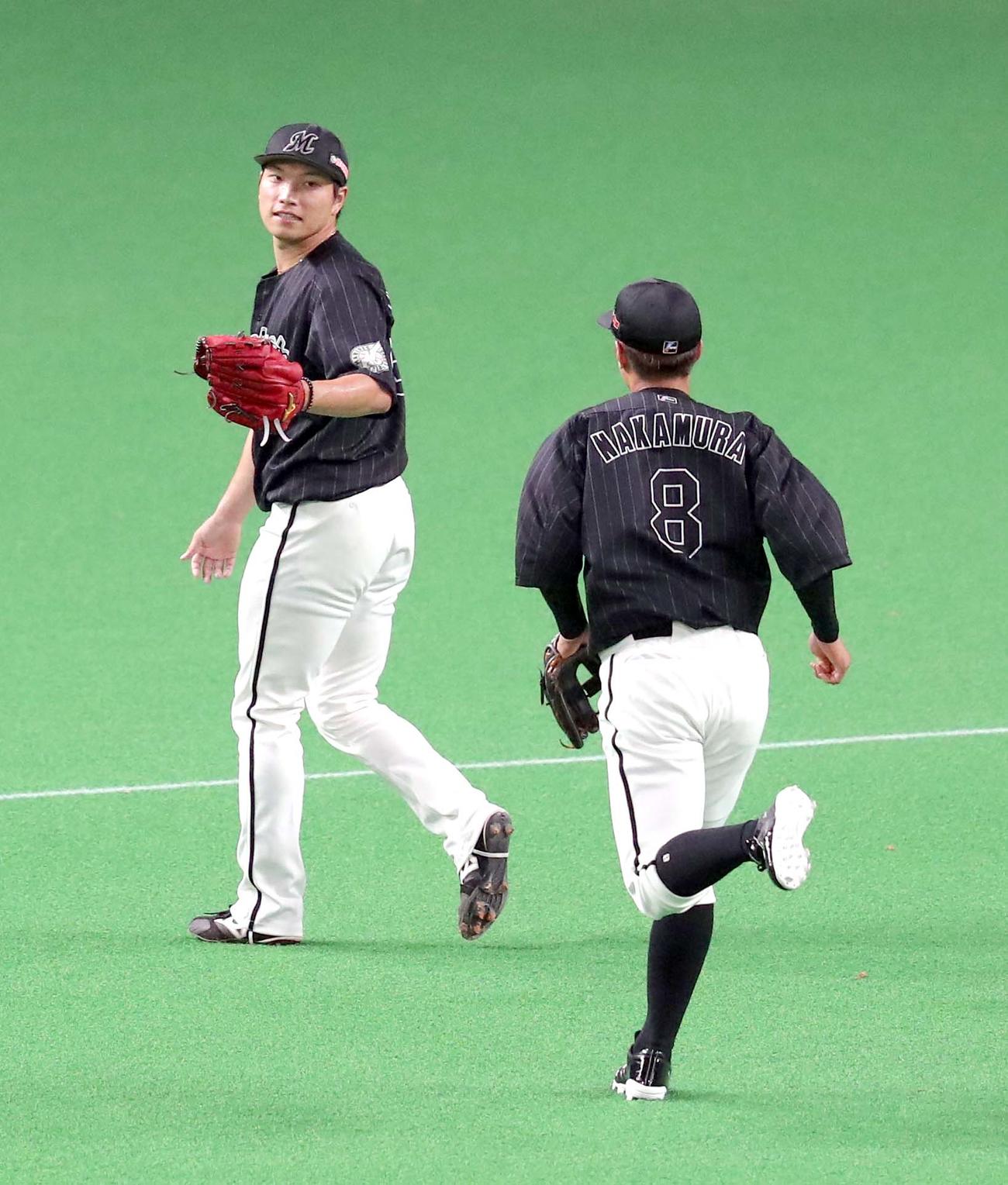 日本ハム対ロッテ　3回裏を無失点に抑え、ロッテ中村奨（右手前）を出迎えながらベンチに戻る岩下（撮影・佐藤翔太）