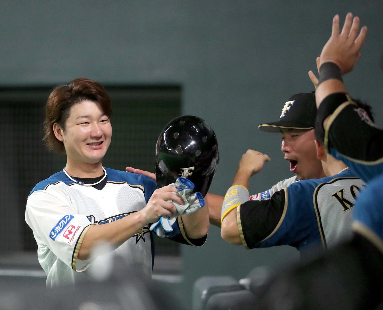 日本ハム対ロッテ　4回裏日本ハム2死三塁、石川亮の左前適時打で生還しチームメートに出迎えられる渡辺（撮影・佐藤翔太）