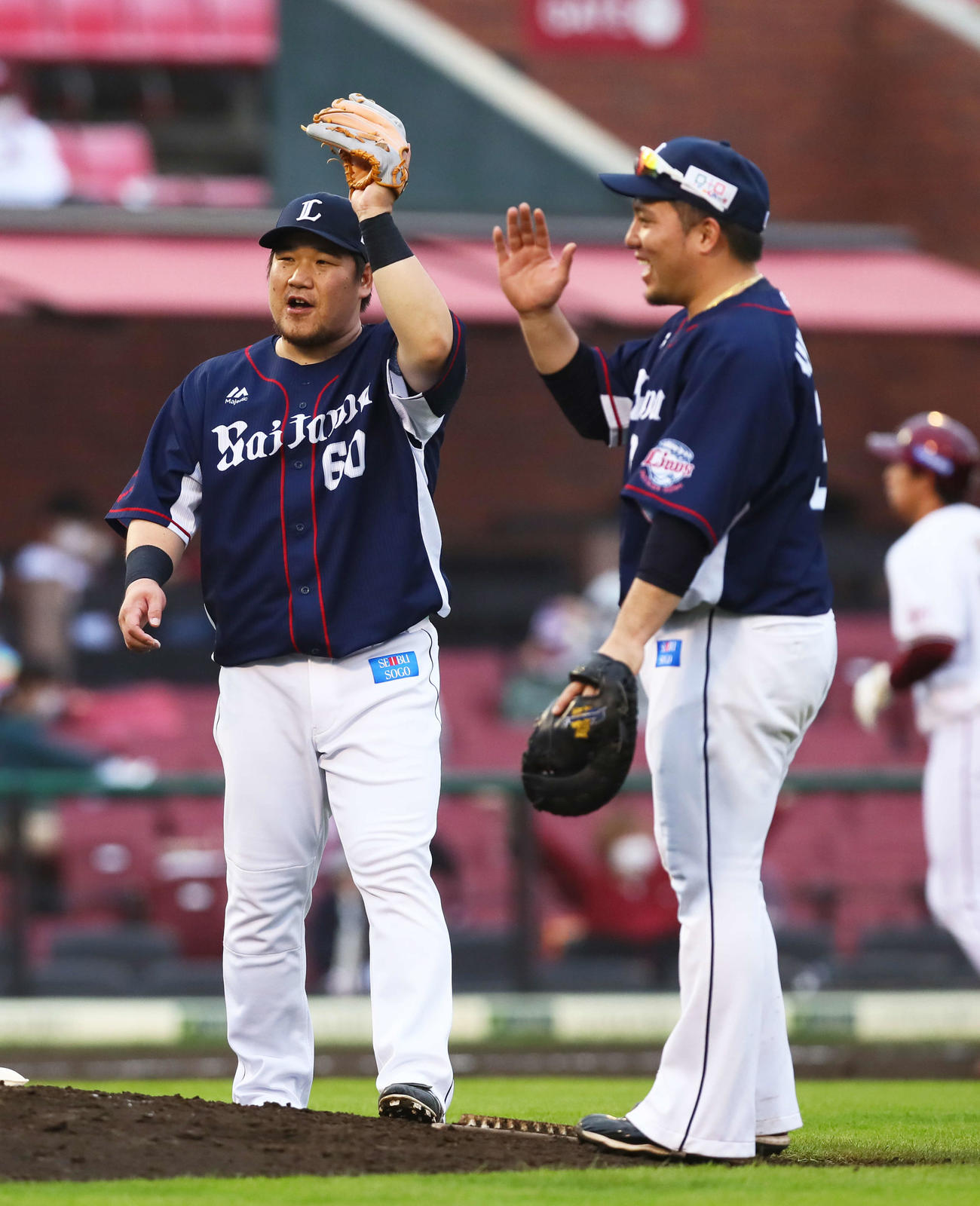 楽天対西武　勝利しエアタッチを交わす西武の中村（左）と山川（撮影・足立雅史）