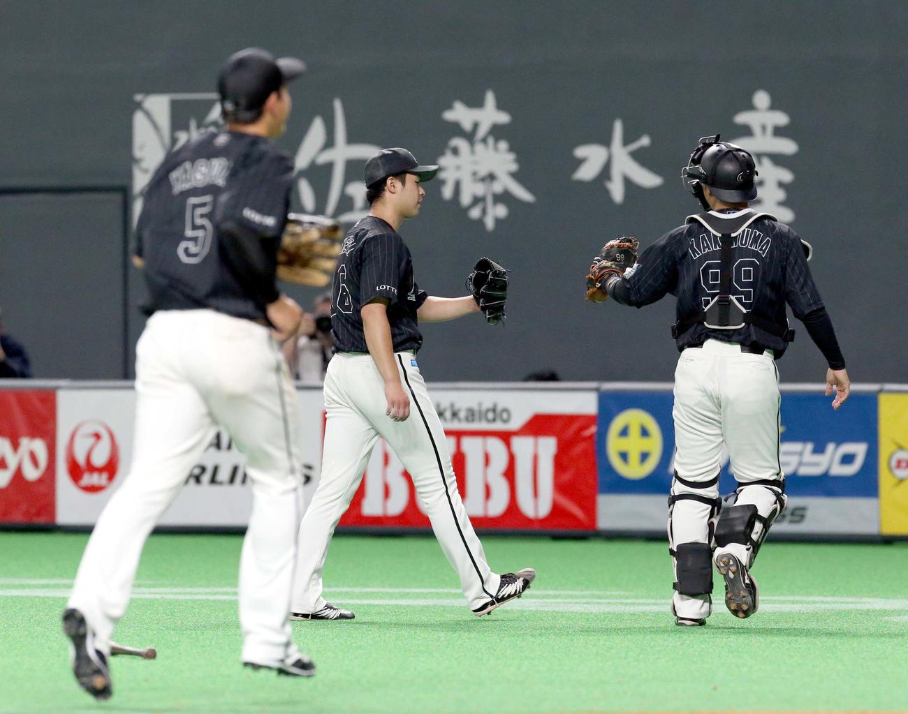 日本ハム対ロッテ　6回裏日本ハム2死一塁、近藤を中飛に仕留めグラブタッチをするロッテ種市と柿沼（右）（撮影・佐藤翔太）
