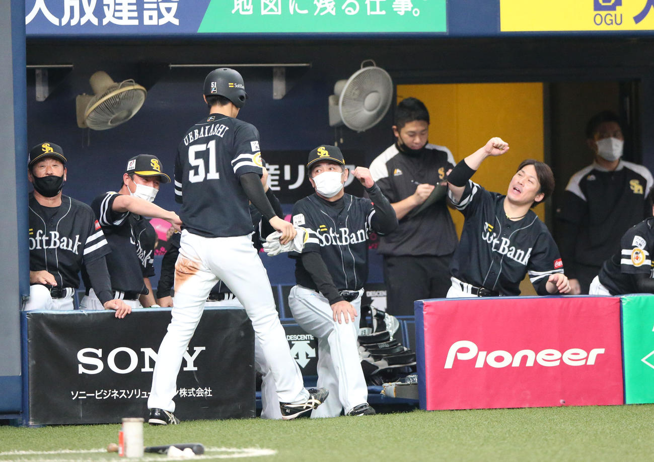 柳田悠岐の右適時二塁打で生還の上林誠知（手前）は工藤公康監督らから出迎えられる（撮影・上山淳一）