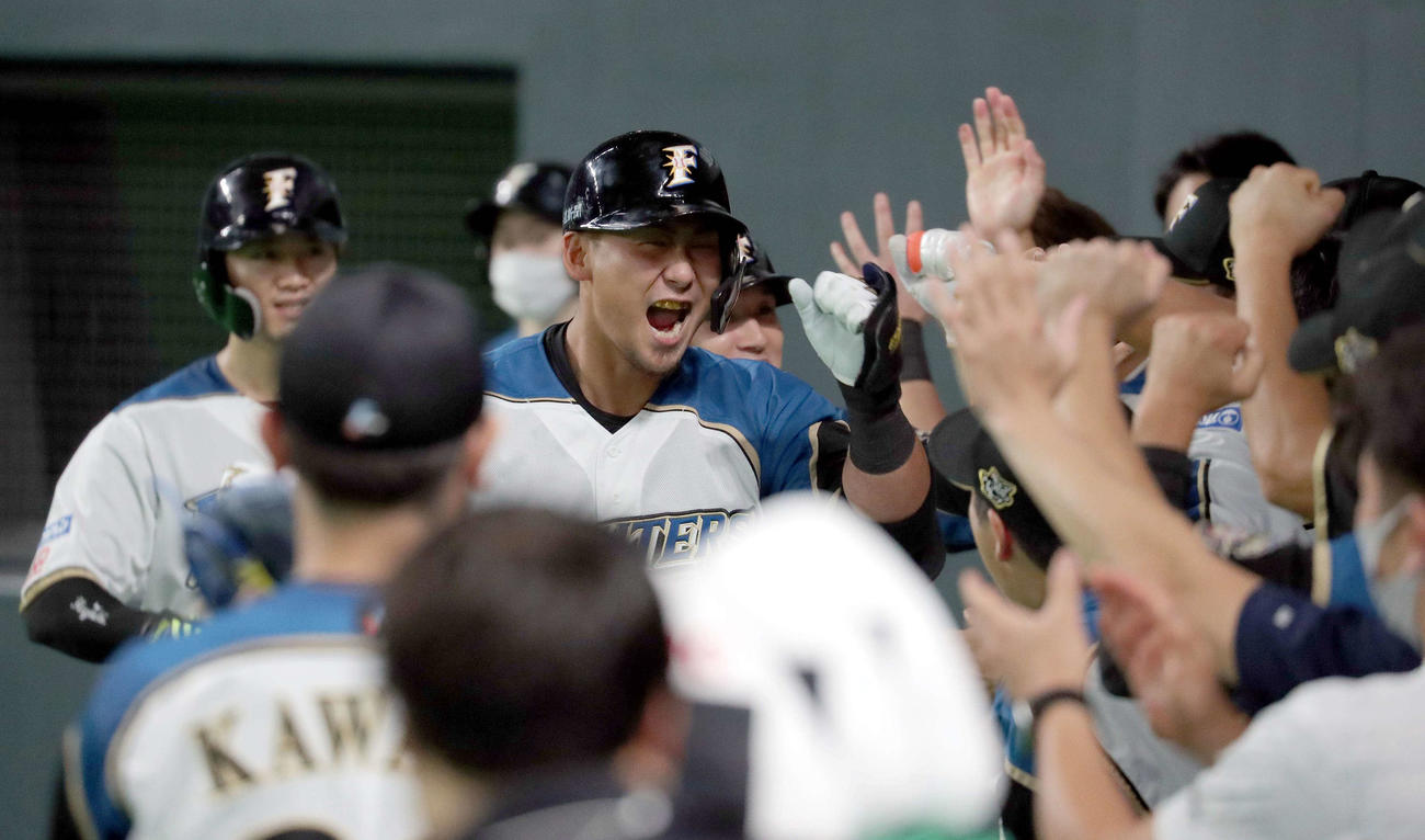 日本ハム対ロッテ　3回裏日本ハム1死一、二塁、中田は左越え3点本塁打を放ちチームメートに出迎えられる（撮影・佐藤翔太）