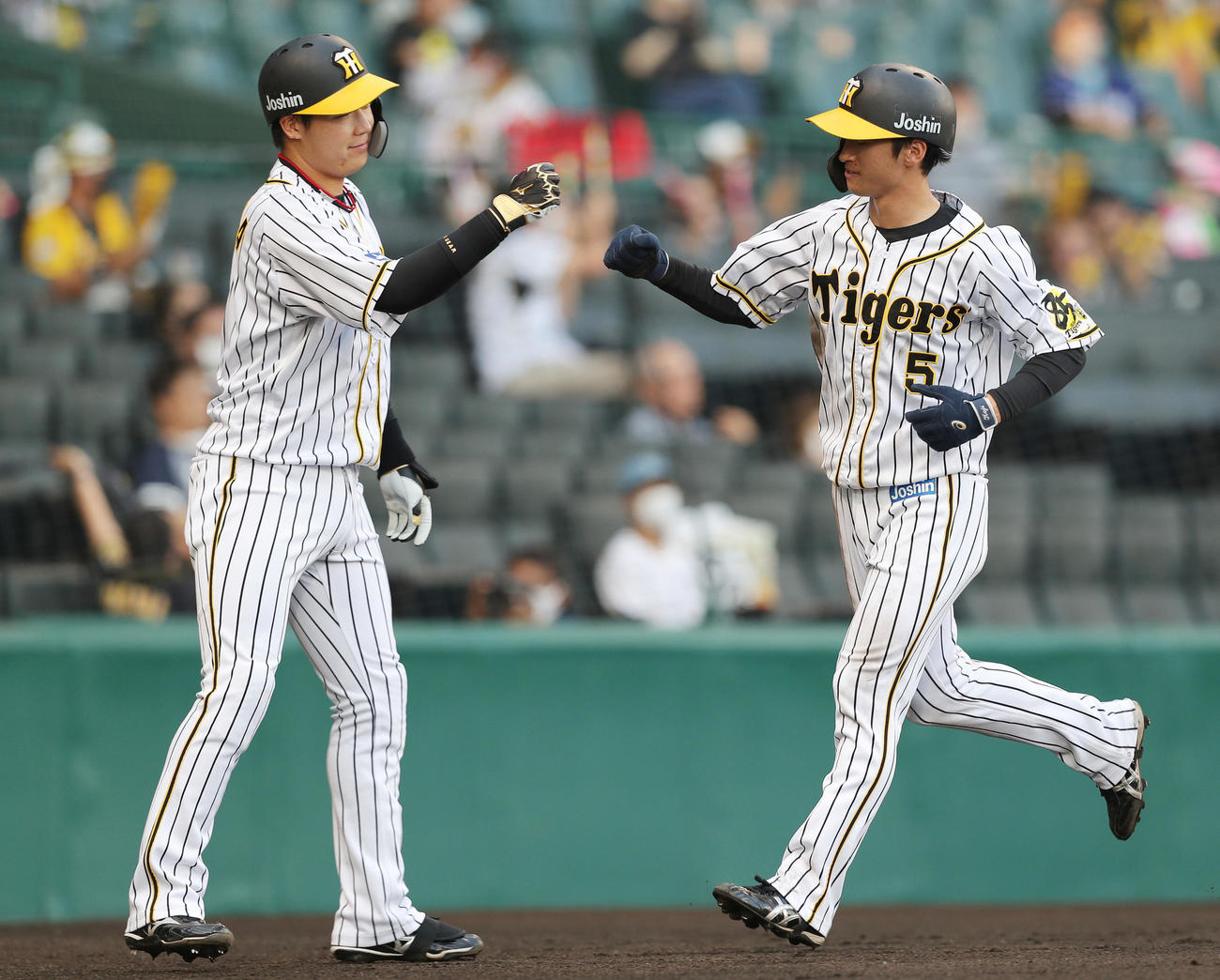 阪神対中日　1回裏阪神無死一、二塁、サンズの適時打で先制の生還を果たし、迎えた大山（左）とエアグータッチする近本（撮影・前田充）
