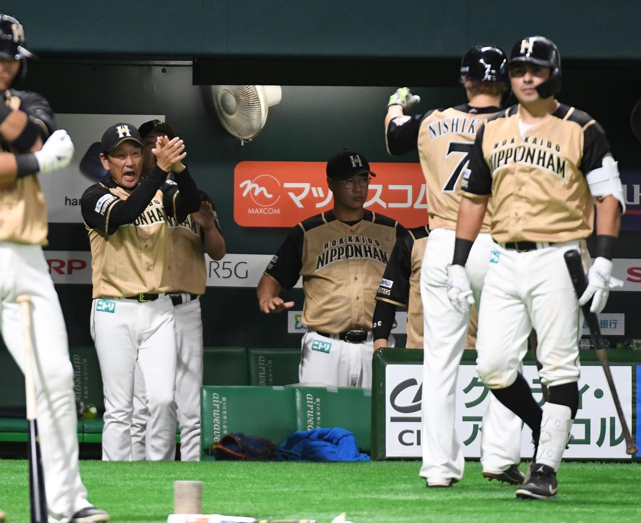 ソフトバンク対日本ハム　7回表日本ハム2死一、三塁、近藤健介の勝ち越し適時打で生還した西川遥輝を出迎える栗山英樹監督（撮影・今浪浩三）