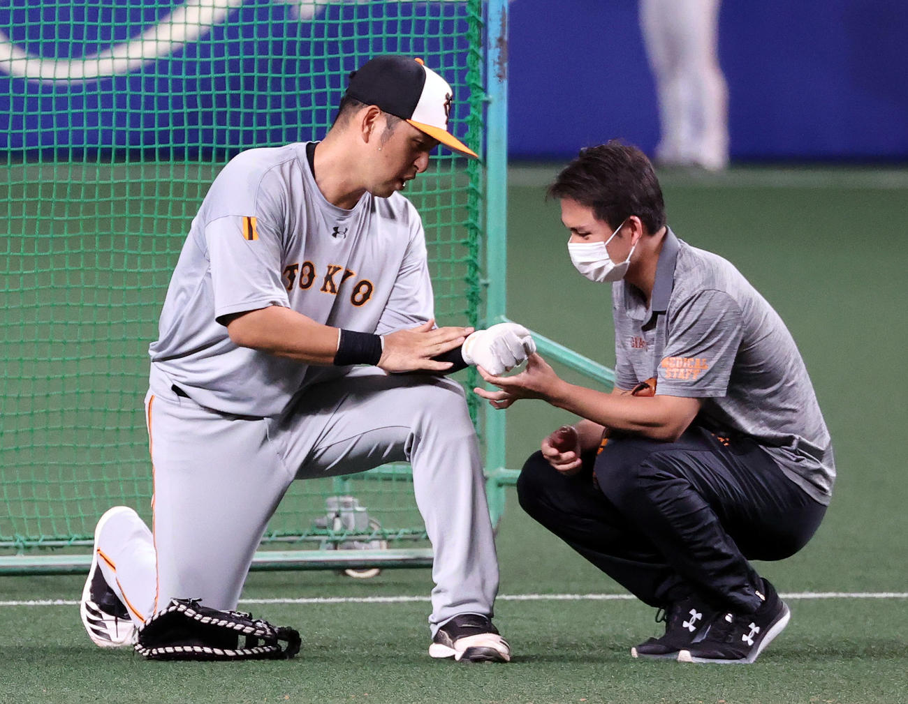 中日対巨人　試合前、打撃練習の打球が左腕に直撃しスタッフに見てもらう中島（左）（撮影・大野祥一）