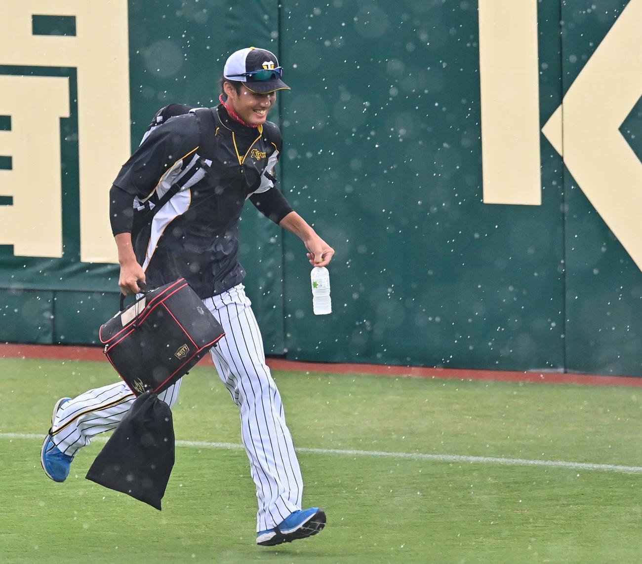 阪神対広島　突然の大雨に見舞われた藤浪晋太郎は笑顔を見せながらグラウンドを引き揚げる（撮影・上田博志）