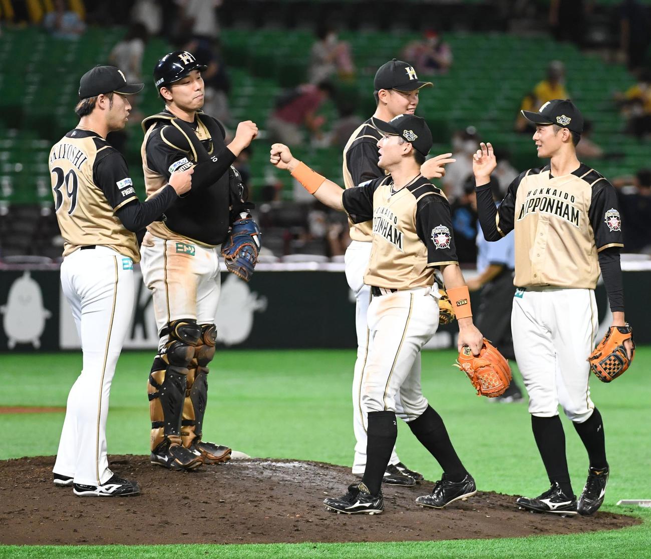 ソフトバンク対日本ハム　ソフトバンクを破りマウンドでエアータッチを交わす秋吉、宇佐見ら日本ハムナイン（撮影・今浪浩三）