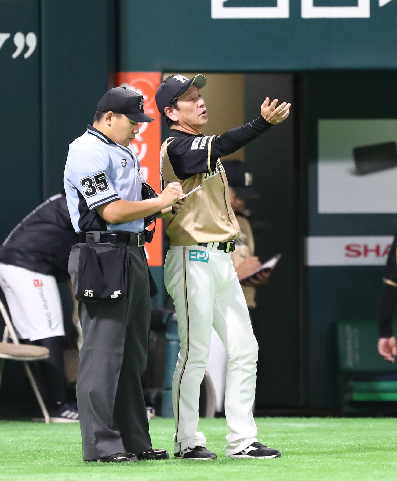ソフトバンク対日本ハム　審判に選手交代を告げる栗山監督（撮影・梅根麻紀）