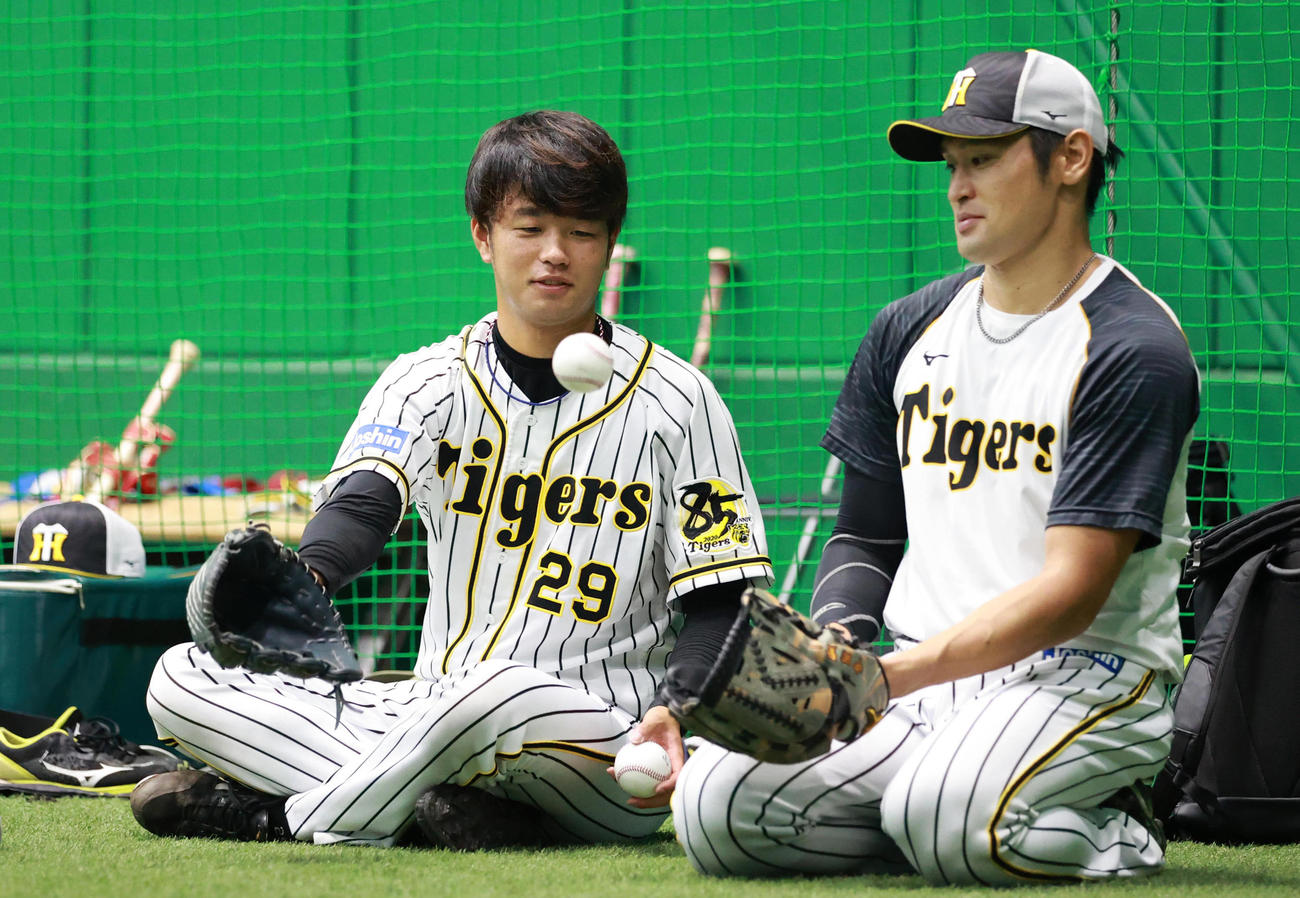 高橋遥人（左）からボールを受ける中田賢一（撮影・清水貴仁）