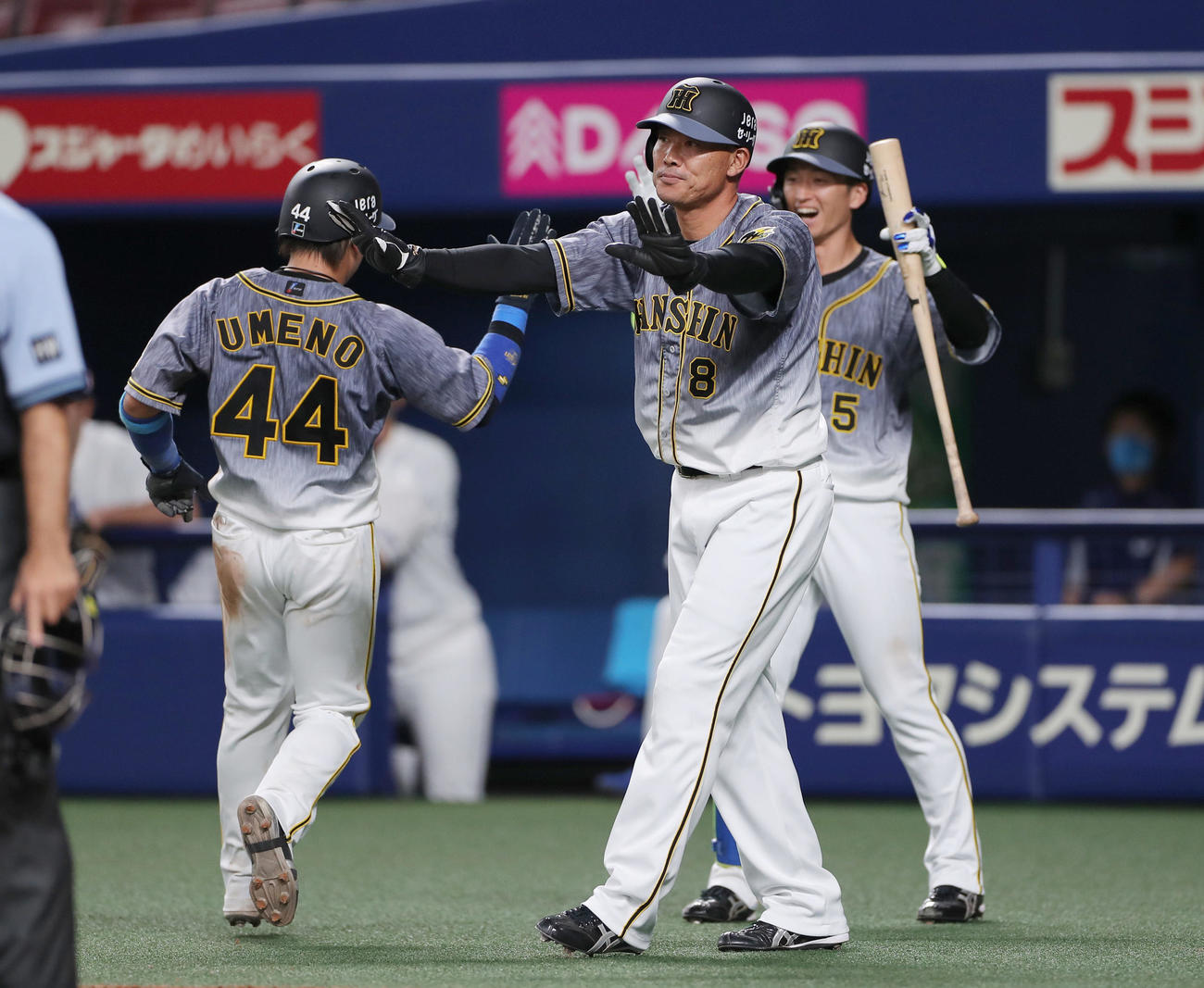 中日対阪神　8回表阪神2死満塁、中谷の2点適時打で生還する梅野（左）を迎える福留（中央）と近本（後方）（撮影・前田充）