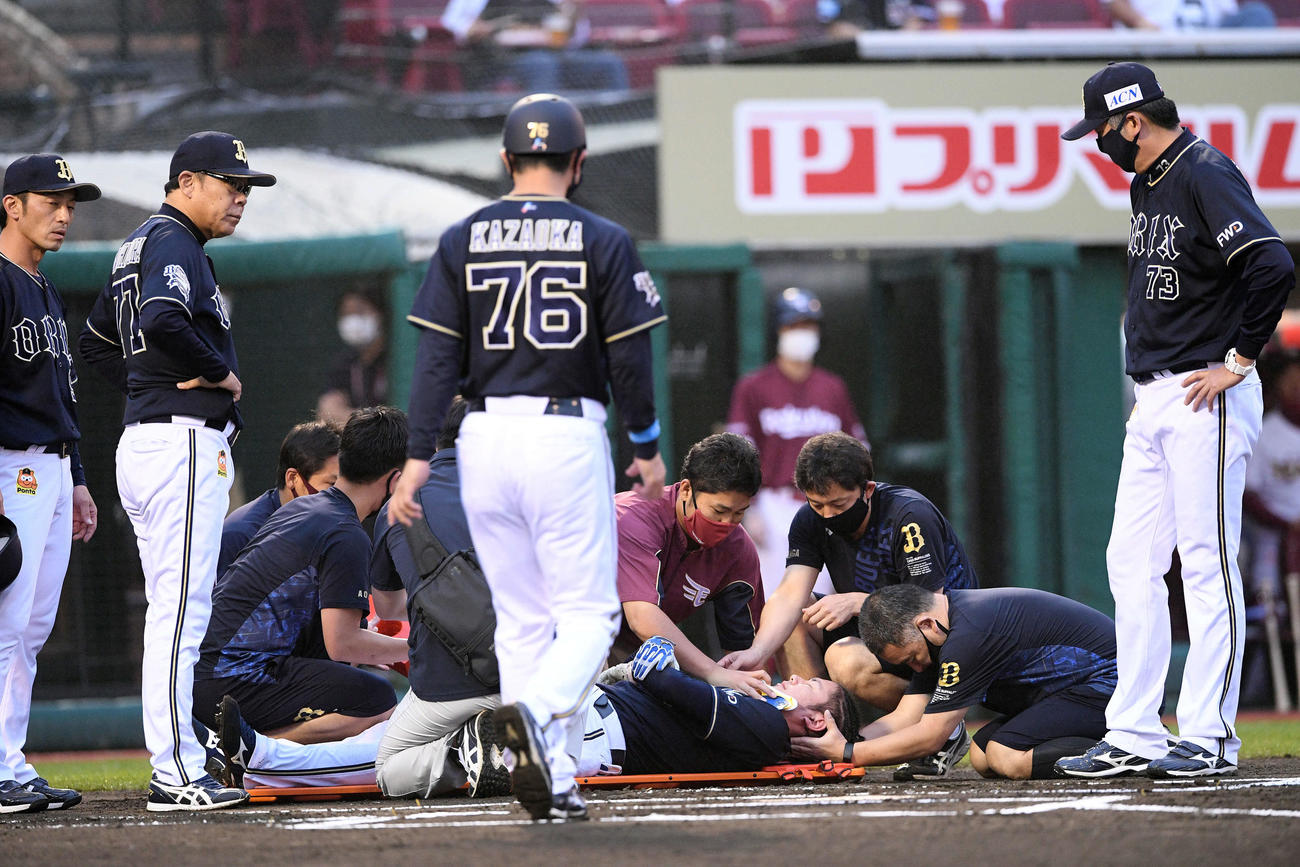楽天対オリックス　1回表オリックス無死二塁、頭部に死球を受けた大城（下）は担架に乗せられる。左から2人目は西村監督（撮影・滝沢徹郎）