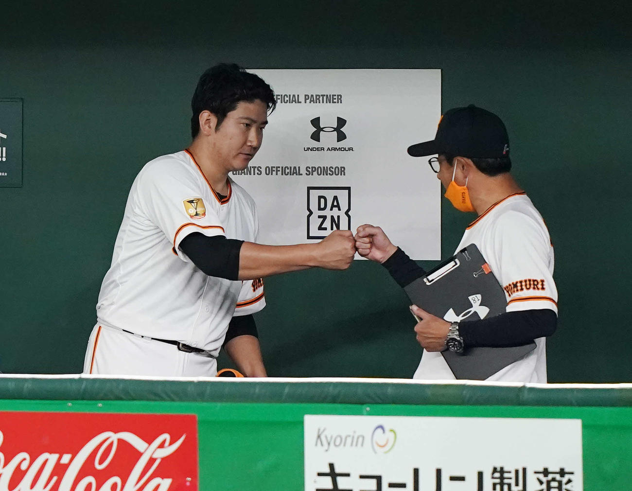 巨人対DeNA　7回表を投げ終え、宮本投手総合コーチ（右）とグータッチを交わす巨人菅野（撮影・鈴木みどり）