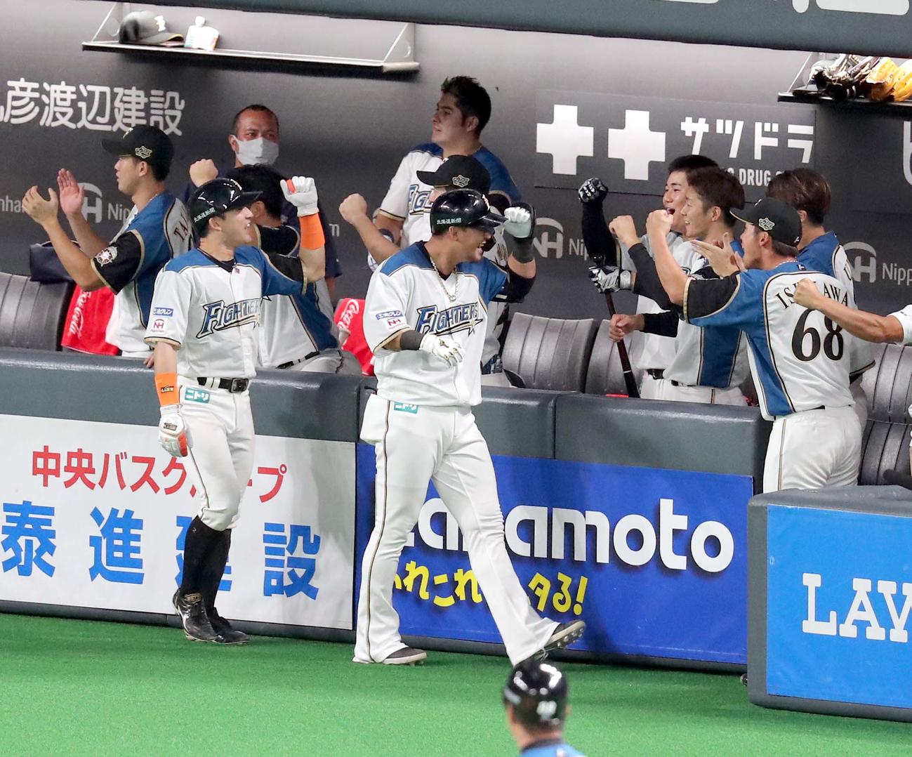 日本ハム対オリックス　7回裏日本ハム2死一、二塁、中田（中央）は左越え3点本塁打を放ちチームメートに出迎えられる（撮影・佐藤翔太）