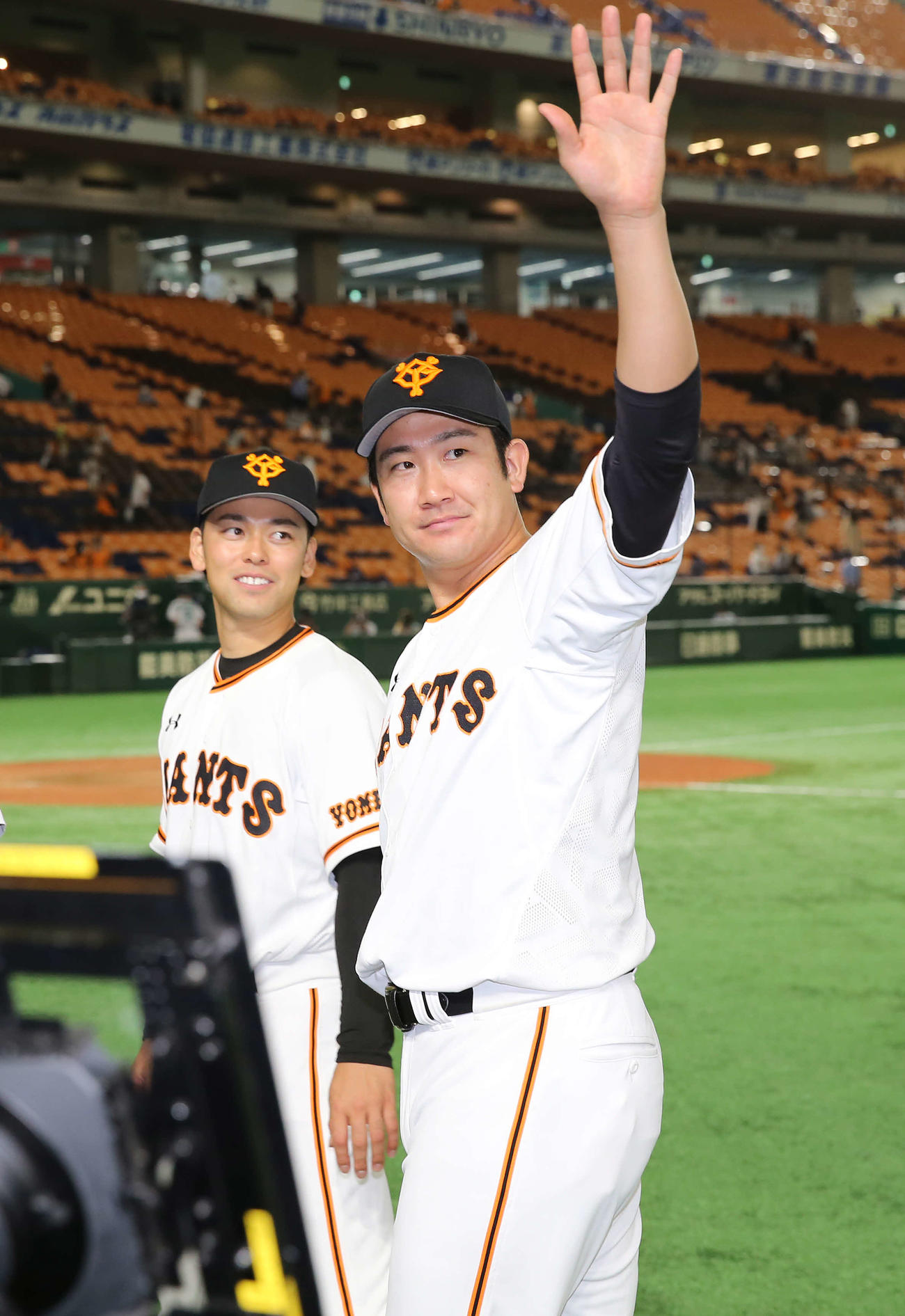 巨人対DeNA　DeNAを下し、勝利投手となった菅野（右）は声援に応えながら引き揚げる。左は高梨（撮影・河野匠）