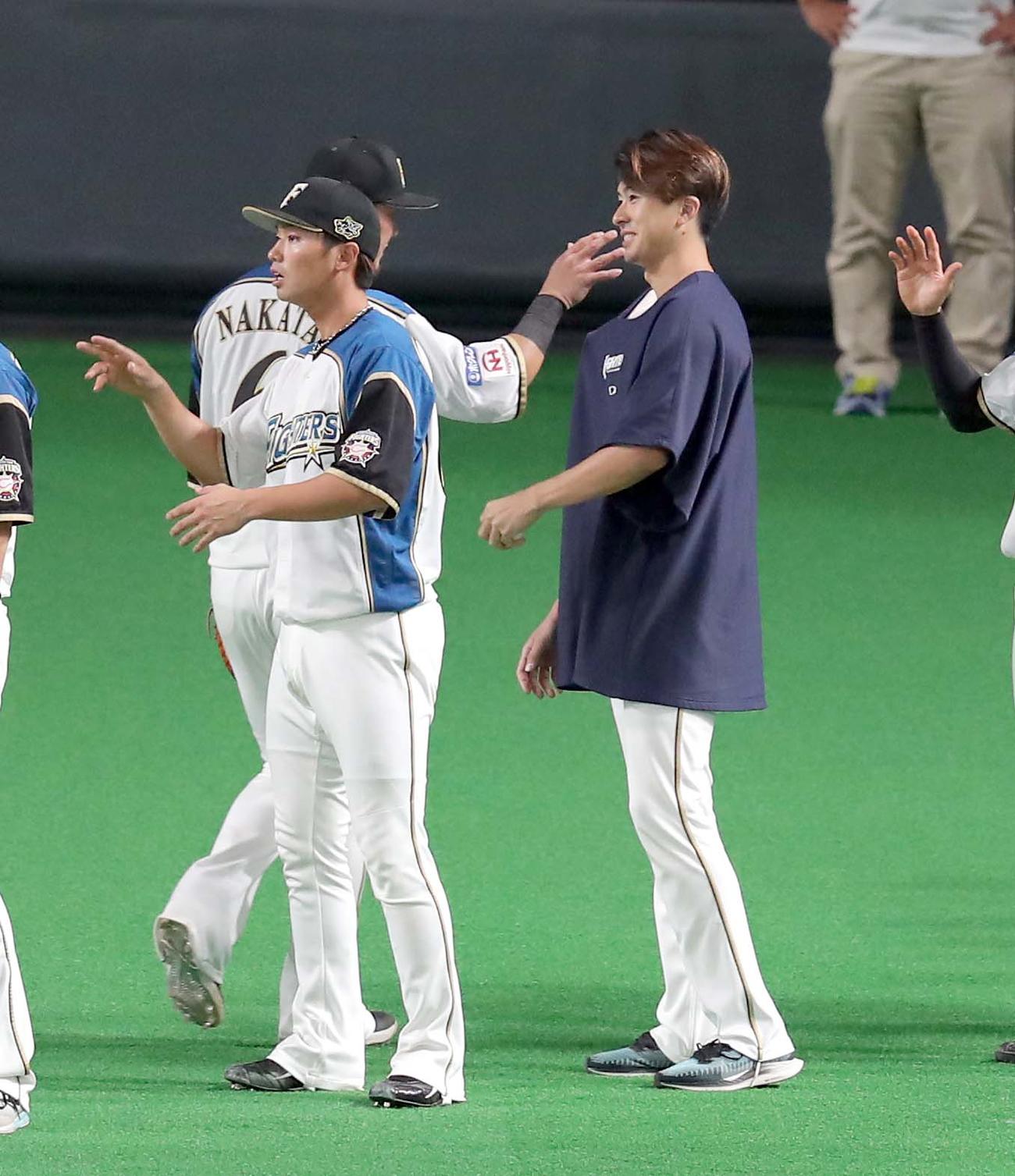 日本ハム対オリックス　試合終了後、笑顔で日本ハム中田を出迎える上沢（右）（撮影・佐藤翔太）