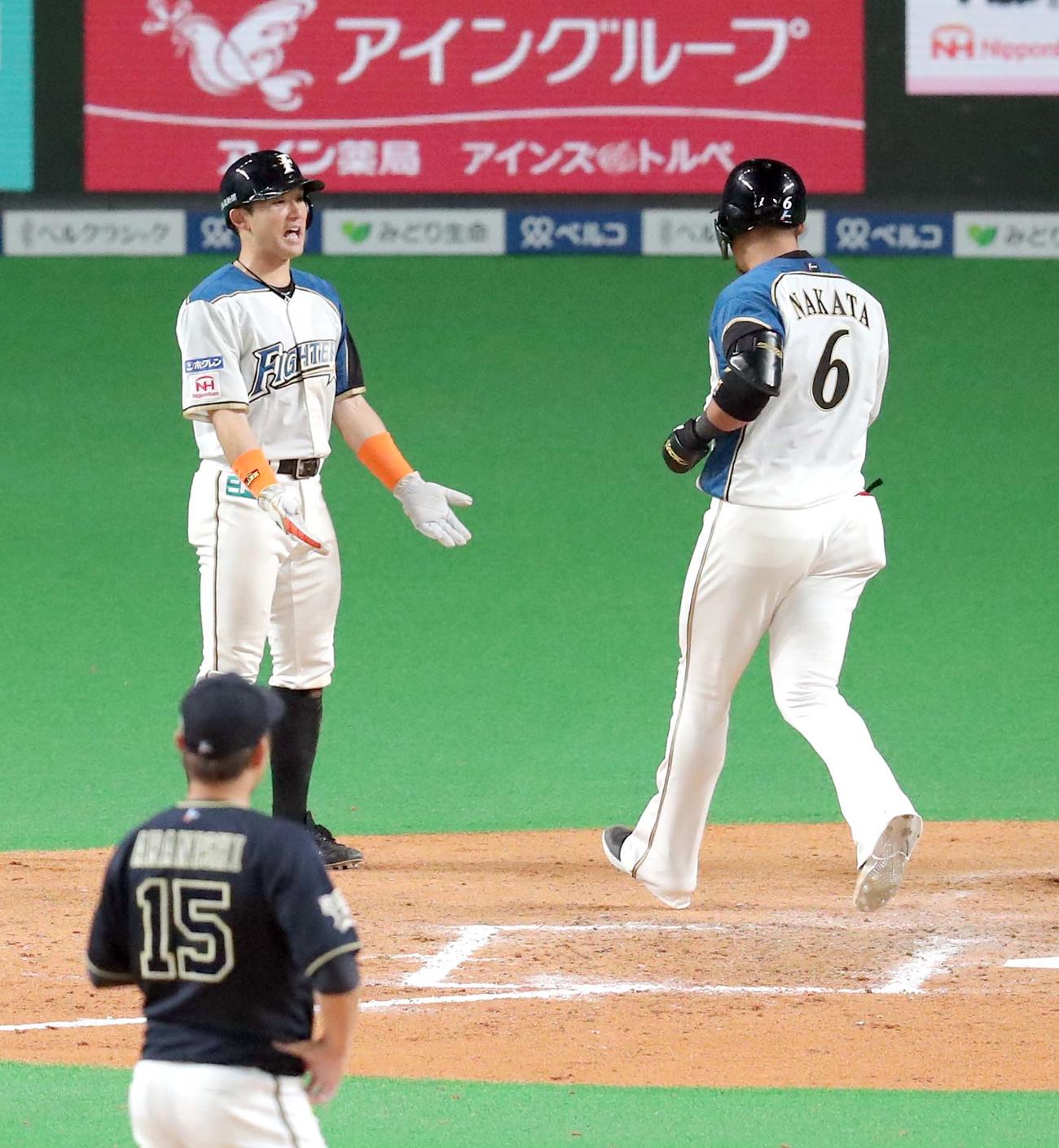 日本ハム対オリックス　7回裏日本ハム2死一、二塁、中田は左越え3点本塁打を放ち杉谷（左）に出迎えられる（撮影・佐藤翔太）