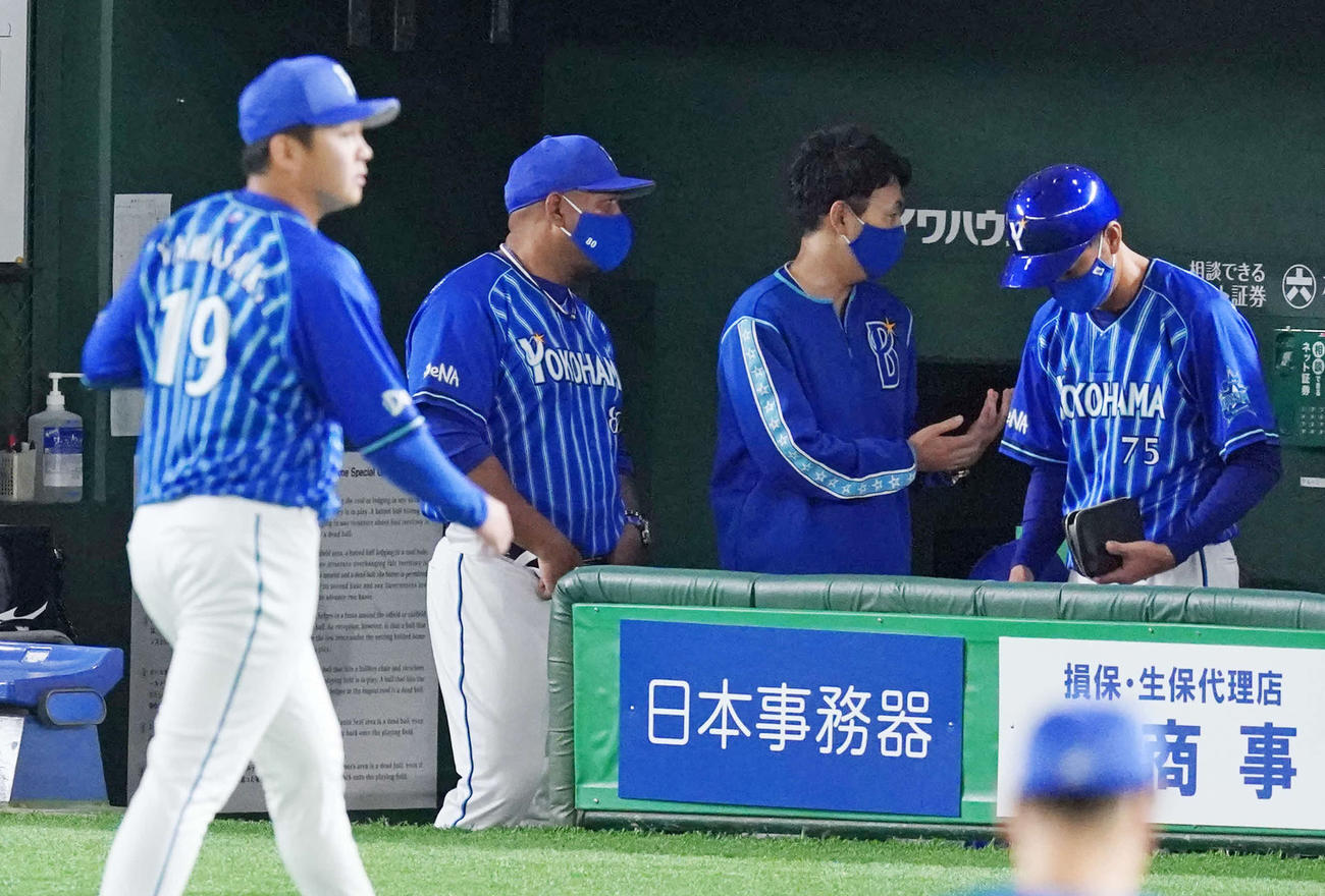 巨人対DeNA　7回裏終了後、DeNAコーチ陣と話すラミレス監督（後方左）。手前はベンチに引き揚げる山崎（撮影・江口和貴）
