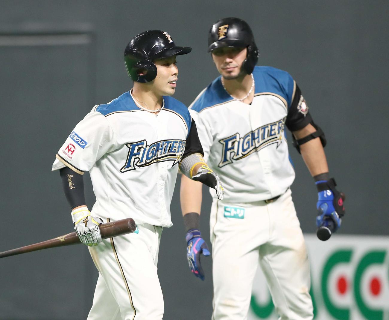 日本ハム対オリックス　5回裏日本ハム1死三塁、右犠飛を放った近藤（左）は大田に出迎えられる（撮影・黒川智章）
