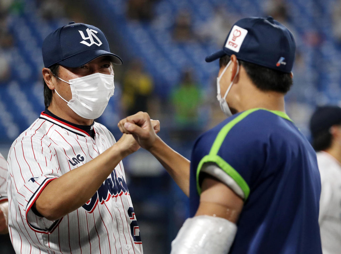 試合後、高橋（右）とタッチを交わす高津監督（撮影・狩俣裕三）