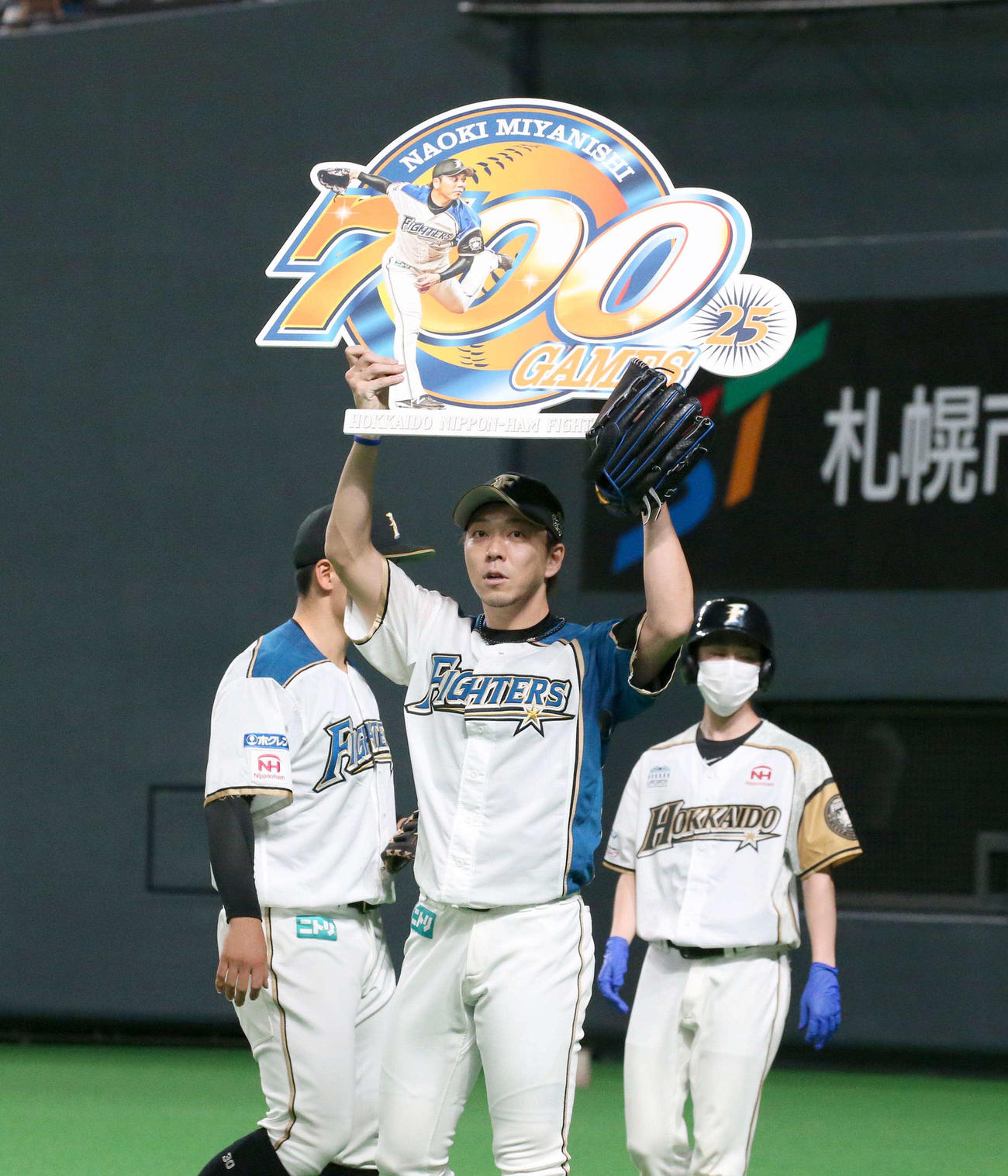 日本ハム対オリックス　通算700試合登板を達成し記念ボードを掲げる宮西（撮影・黒川智章）