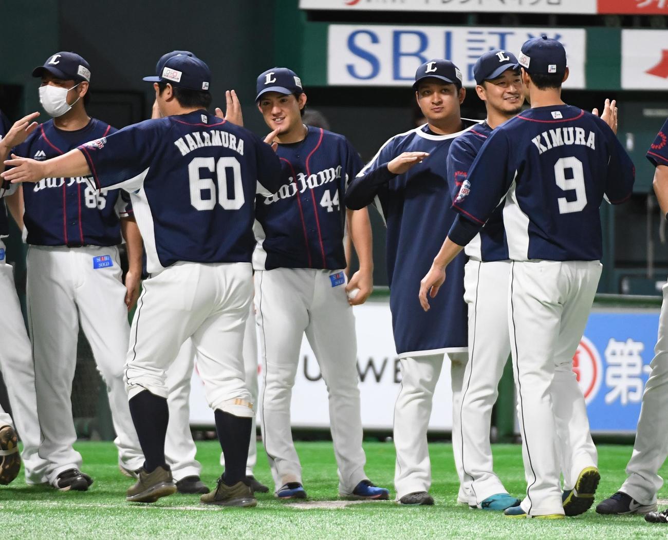2勝目を挙げた与座海人（中央）はナインを出迎える（撮影・今浪浩三）