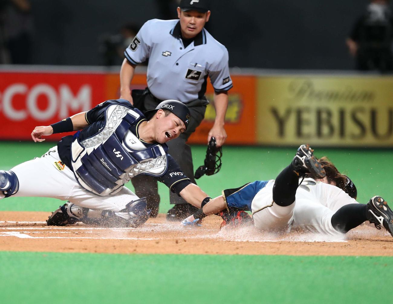 日本ハム対オリックス　1回裏日本ハム2死一、三塁、横尾の左前打で生還する一塁走者の渡辺諒。捕手伏見（撮影・黒川智章）