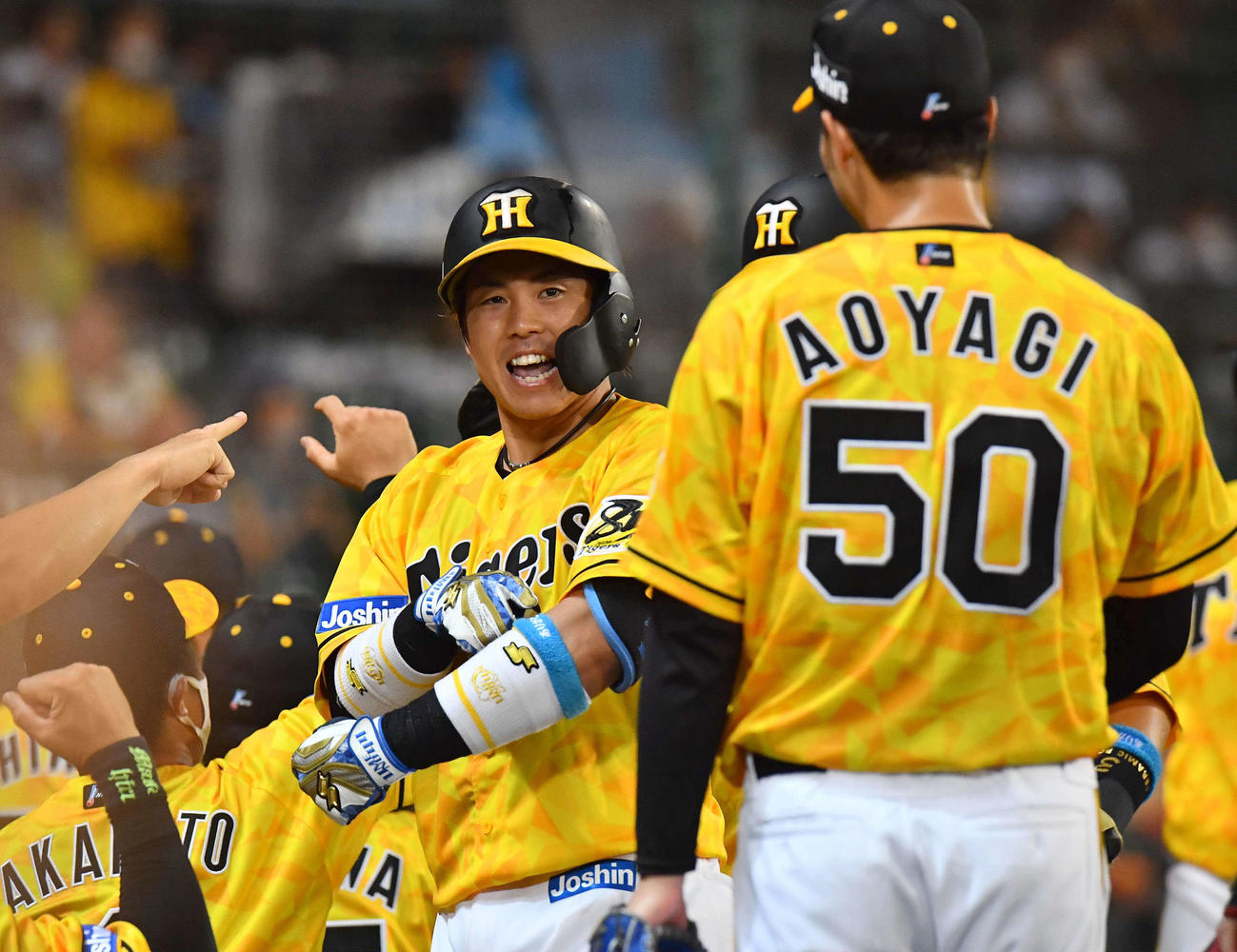 阪神対DeNA　4回裏阪神2死一、二塁、先制3点本塁打を放った梅野はサポーターに刺繍されたありがとうを指さし笑顔を見せる。右は先発青柳（撮影・上田博志）