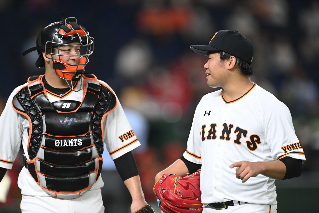 巨人対広島　3回表を投げ終え、岸田（左）と話しながらベンチへ戻る巨人田口（撮影・鈴木みどり）