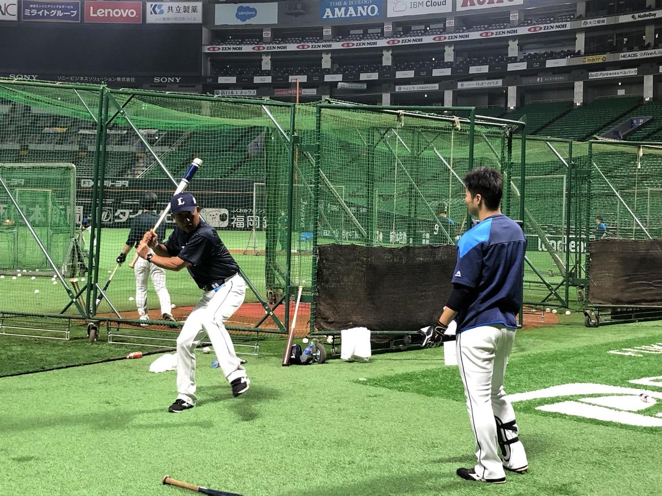 試合中止のためチーム練習を行い、西武鈴木（右）に打撃指導を行う辻監督（球団提供）